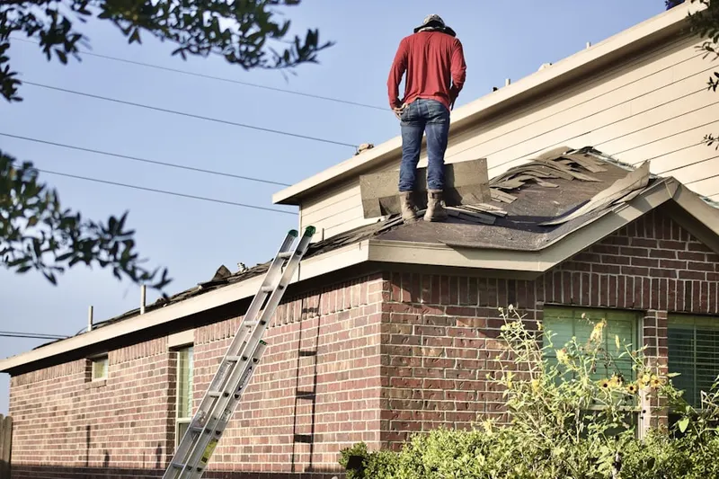Professional roofer working on a residential roof in Poston